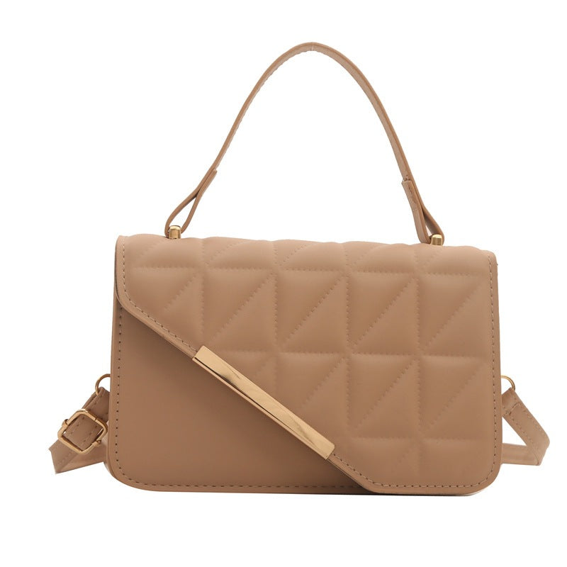 Beige quilted handbag with a shoulder strap on a white background