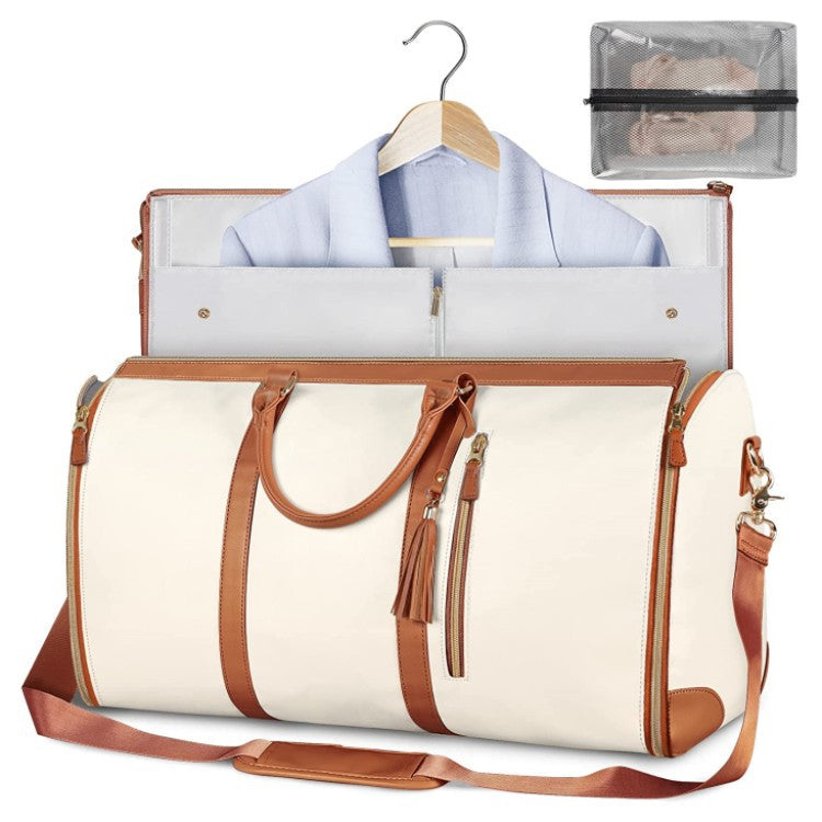 White travel bag with brown leather straps and trim, open to reveal a shirt on a hanger and a clear pouch.